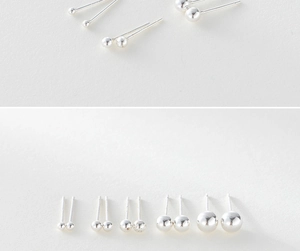 Macro shot of multiple sizes of 925 sterling silver round bead stud earrings on paper