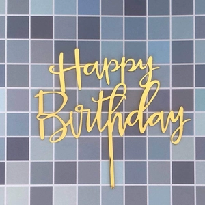 Elegant gold acrylic Happy Birthday cake topper with artistic script on mosaic tile background