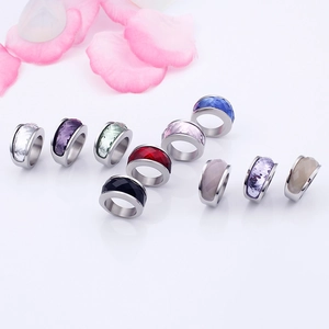 Polished stainless steel rings with multi-color faceted crystals on white mirror background