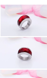 Three-sided view of stainless steel ring with a large faceted dark red crystal