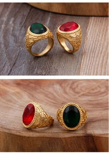 Détails d'une bague vintage dorée avec pierres rouges et vertes et gravures fines