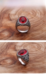 Détail d'une bague vintage pour homme avec pierre rouge et gravures de vigne sur l'anneau
