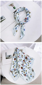 Detail of light blue silk scarf featuring zebra print and leopard heart patterns