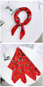 Detail of red silk heart scarf with zebra pattern tied and folded on white display