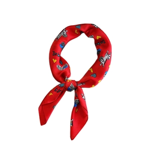 Red silk-like square scarf with zebra and heart print tied in a stylish knot