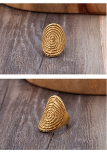 Detail view showing the golden spiral dotted texture on a vintage punk oval ring