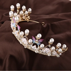 Detail of golden princess crown featuring purple butterflies, pearls, and crystals