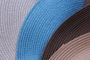 Macro texture of woven placemats in grey blue brown and beige colors with glossy finish
