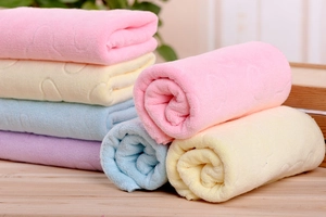 Close-up of soft microfiber bath towels with embossed bear patterns in pastel colors
