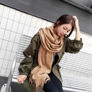 Close-up of soft camel cashmere scarf featuring fluffy texture and classic tassel edges