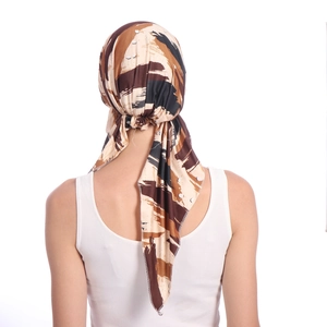 Back view of a printed milk silk turban hat with abstract brown and beige patterns