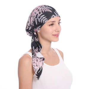 Detail view of printed headscarf with pink and white leaf patterns on black fabric