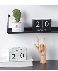 Gros plan sur un calendrier perpétuel minimaliste en bois noir et blanc sur étagère