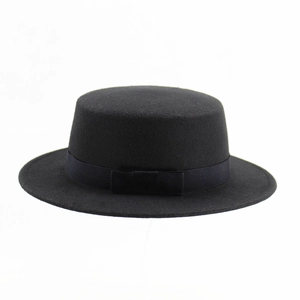 Detail of black flat top wool felt fedora featuring a grosgrain ribbon and side bow