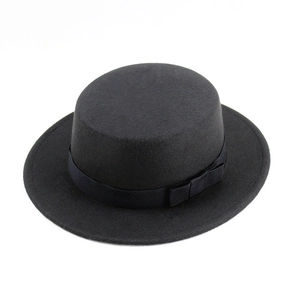 Close-up of a black wool boater hat featuring a stiff flat top and silk ribbon bow