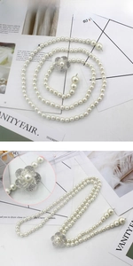Détail de ceinture en perles avec fermoir fleur en strass brillant et perles lustrées
