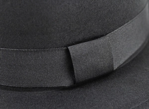 Detail of the black grosgrain ribbon and bow on a classic wool felt flat top boater hat
