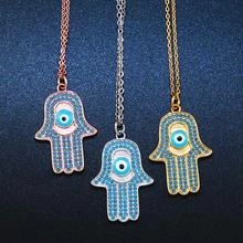 Detailed close-up of Hamsa Hand pendants in gold, rose gold and silver with Evil Eye charms