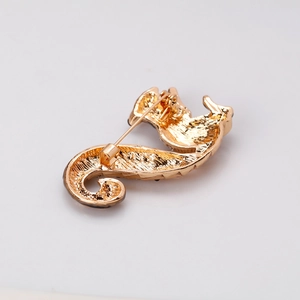 Golden seahorse brooch with detailed metal texture and secure pin clasp on back