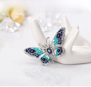 Detail of butterfly brooch with blue enamel wings and sparkling white crystals