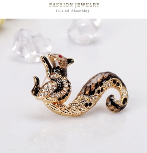 Detail view of gold-tone squirrel brooch with leopard print enamel and white rhinestones