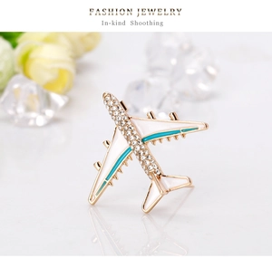 Detailed macro view of airplane brooch featuring gold finish and sparkling crystal accents