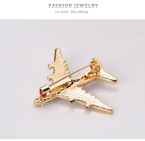 Detail view showing the gold airplane brooch back with metal pin and polished finish