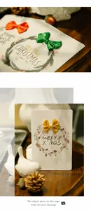 Detailed view of white Christmas cards featuring festive wreaths and ribbon bows