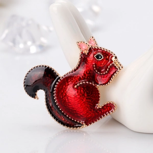 Cute squirrel brooch in red enamel with gold plating on a white display stand