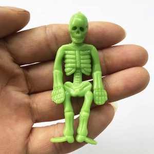 Green TPR flexible skeleton toy held in hand showing creative mini skull design