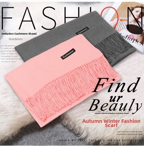 Detail of pink and dark grey imitation cashmere scarves with soft fringe and logo labels