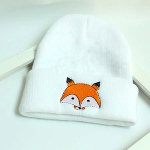 Détail du bonnet tricoté blanc pour bébé avec broderie d'un renard orange mignon