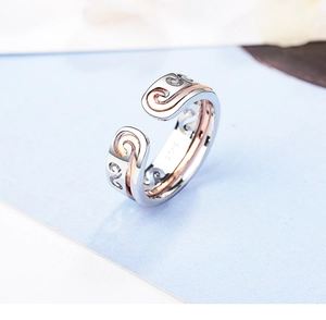 Macro shot of rose gold inner band with silver filigree cloud pattern on the open ring