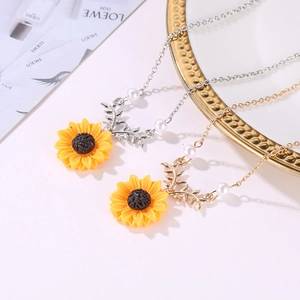 Vue détaillée de colliers tournesol avec accents de perles en tons or et argent