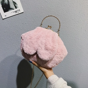Detailed close-up of pink faux fur plush handbag featuring vintage golden engraved handles