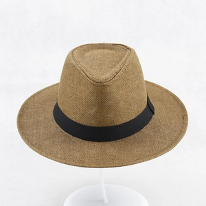 Detail of the woven texture and black ribbon on a brown wide brim straw sun hat