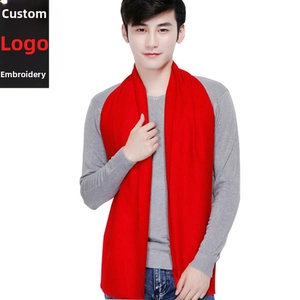 Detail of red knit winter scarf for men with smooth texture on a grey sweater