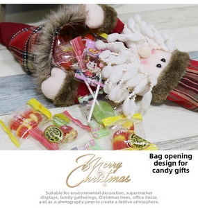 Detail of plush Santa Claus gift bag with red plaid fabric and festive candy fillings