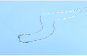 Detailed close-up of a silver elk antler pendant necklace on a soft blue background