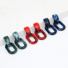 Trois paires de boucles d'oreilles géométriques en résine verte, rouge et bleue marbrée