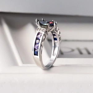 Elegant silver ring featuring oval rainbow zircon and sapphire blue side stones