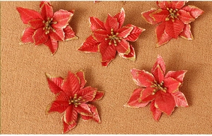 Detail of red artificial poinsettia flower with gold glitter edges for Christmas decor