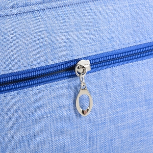 Macro shot of durable blue woven fabric with high-quality silver metal zipper detail