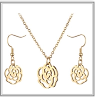Close-up of golden hollow rose pendant necklace and matching earring jewelry set