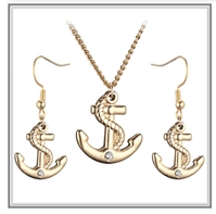 Detail of gold anchor jewelry set featuring a necklace and hook earrings with crystals