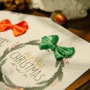 Elegant Christmas greeting card with green wreath, festive bows and Merry Christmas text