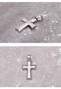 Macro detail of silver Ankh cross pendant with layered metal design on stone surface