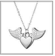 Macro shot of silver winged heart pendant on a layered stainless steel chain