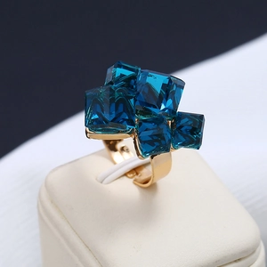 Dettaglio di anello aperto placcato oro con cristalli cubici blu intenso