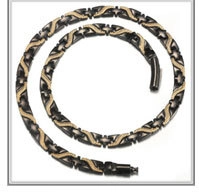 Close-up of black and gold link necklace with baroque freshwater pearl on white background
